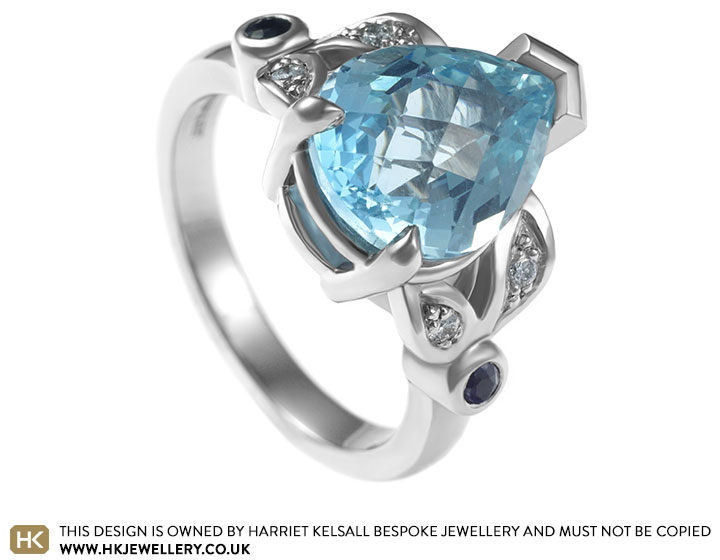 A dramatic lace inspired palladium and aquamarine engagement ring