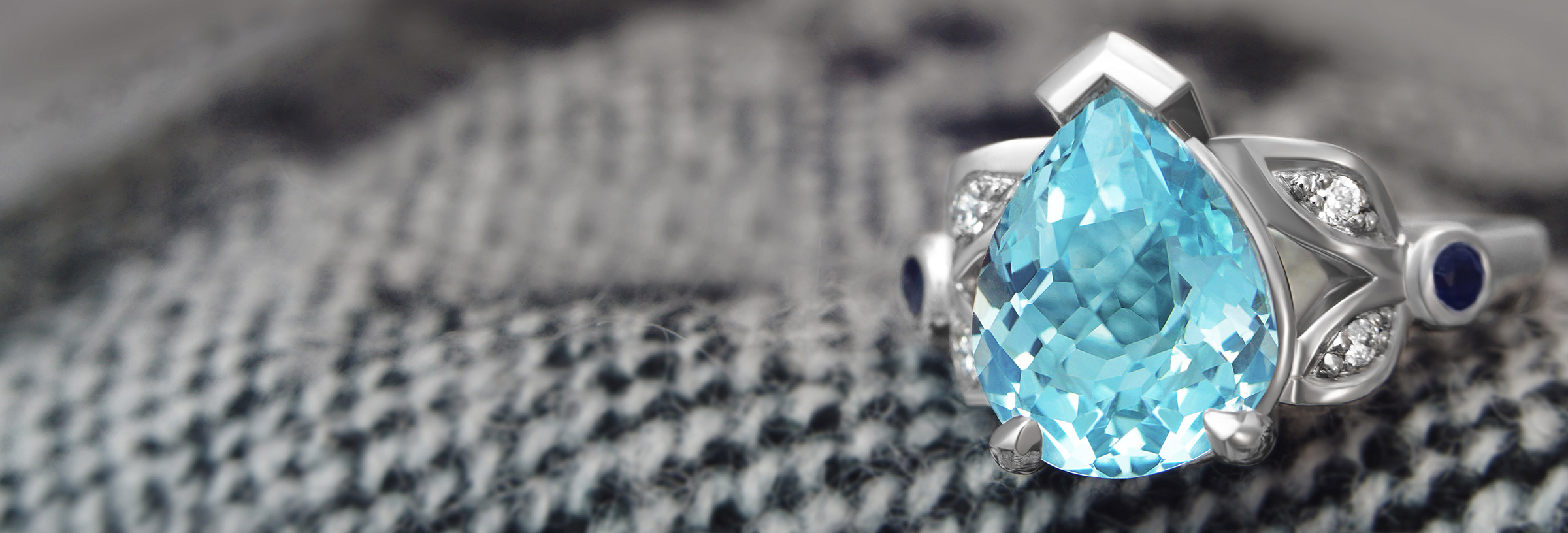 A dramatic lace inspired palladium and aquamarine engagement ring