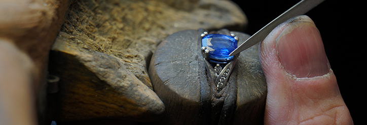 Blue sapphire being set into engagement ring