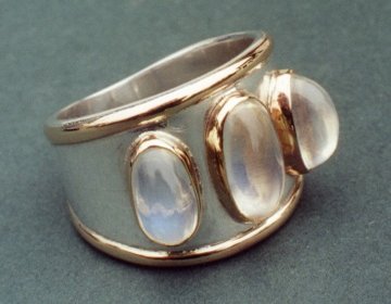 Sterling silver triple moonstone ring with 9ct gold edgings and settings.