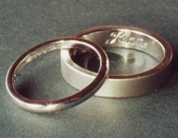 A Sterling silver wedding ring with hand engraved lettering.