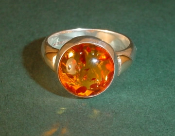 Sterling silver dress ring with amber and 9ct gold details.