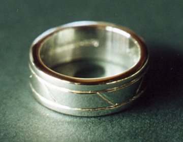 A Sterling silver wedding ring with engraved geometric pattern.