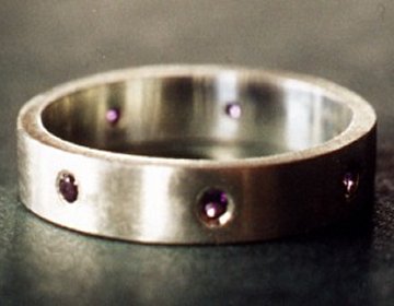 A Sterling silver wedding ring set with amethysts.