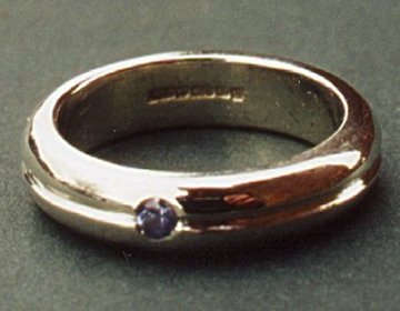 A 9ct white gold wedding ring set with a single Ceylon sapphire. 