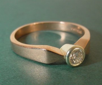 A 9ct rose gold engagement ring with a white gold setting and a 3.6mm diamond 