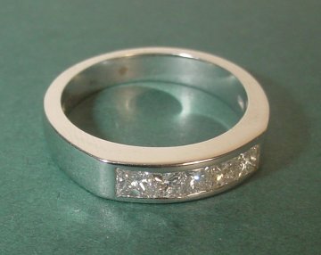 An 18ct white gold engagement ring with 5 X 2.5mm princess cut diamonds.