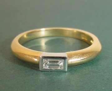 An 18ct yellow gold engagement ring with a white gold setting for a
diamond 