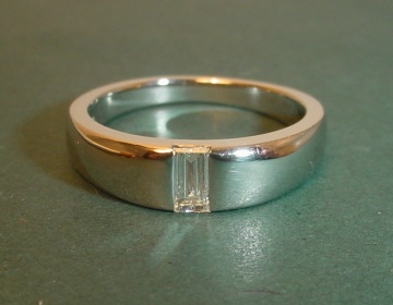 Platinum solitaire with a side set HSI baguette cut diamond.