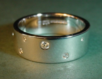 A 9ct white gold wedding ring set with diamonds