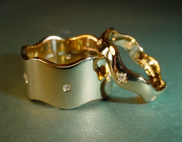 A pair of yellow gold wedding rings set with diamonds