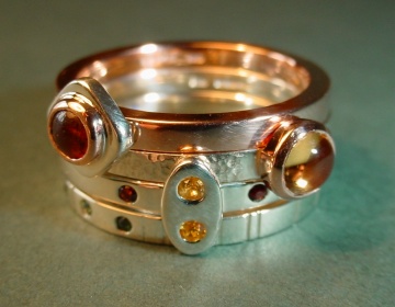 A set of 4 40th birthday celebration stacking rings with amber, garnets, citrine, sapphire and troumaline