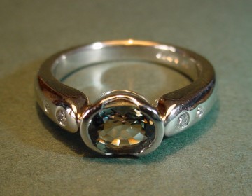 platinum engagement ring with rare green sapphire and shoulder diamonds