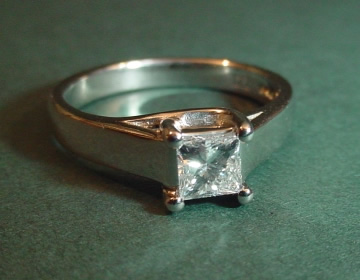 Simple platinum cross-over claw ring with 0.44cts diamond