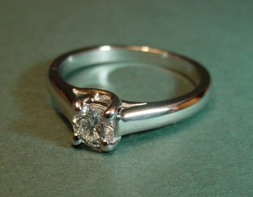 Simple platinum 0.28cts solitaire with cross over setting details