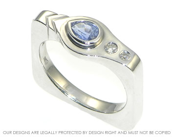 Unusual softened square ring with a pear shaped sapphire and diamonds