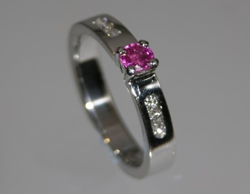 Platinum engagement ring with 0.16cts pink sapphire and channel set diamonds