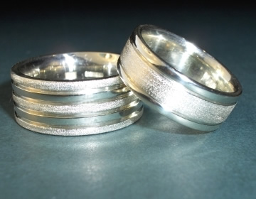 Pair of white gold rings with contrasting finishes.