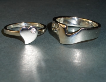 His and hers interlocking 9ct white gold engagement rings.