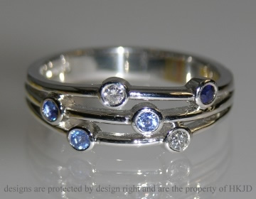 Platinum ring with diamonds and various tones of blue sapphires