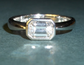 Bespoke engagement ring with emerald cut 0.76cts diamond.