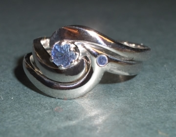 Platinum shaped wedding ring with a blue sapphire.