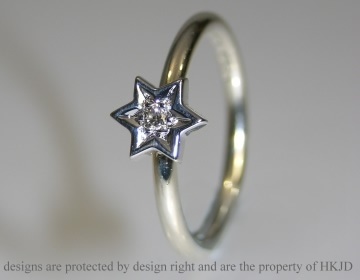 White gold ring with star mounted brilliant cut diamond