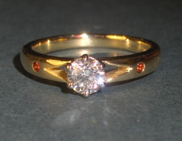 Bespoke engagement ring with diamond and shoulder garnets.