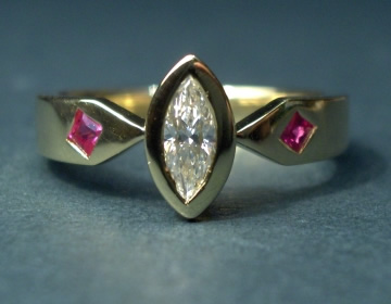 Bespoke engagement ring with marquise central diamond and rubies