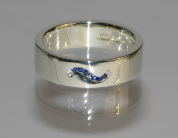 Bespoke eternity ring with wave shape of channel set sapphires and diamonds.