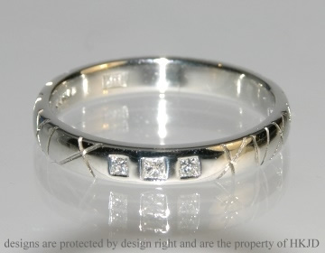 Platinum ring with three diamonds and stylised engraving