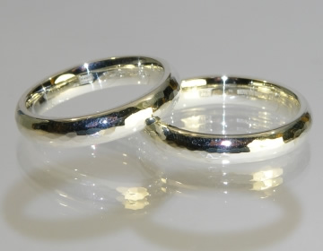 A pair of bespoke hammer finished white gold wedding rings