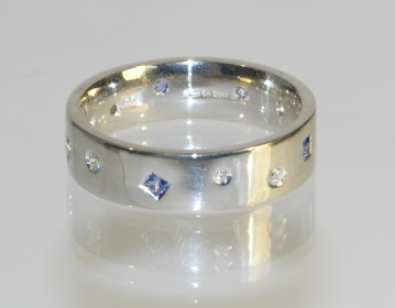 Bespoke scatter set eternity ring with randomly set gemstones.