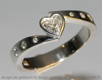 18ct white gold engagement ring with a 0.32ct heart shaped diamond and brilliant cut HSI shoulder diamonds