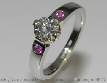 Bespoke platinum engagement ring with pink sapphire side stones and customers own brilliant cut diamond. 