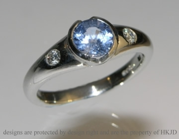 A platinum commissioned engagement ring with astunning light blue sapphire.