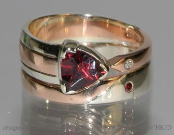 Pair of commissioned white and rose gold wedding bands with garnet and diamonds.