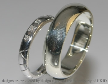 A pair of 9ct white gold commissioned wedding bands with engraved lines. 