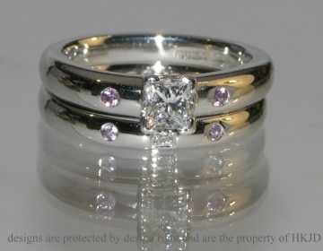 Commissioned platinum wedding ring with a  diamond and pink sapphires