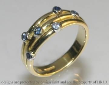 18ct white and yellow gold commissioned eternity ring with scatter set sapphires.