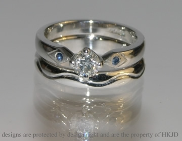 Bespoke ladies platinum wedding ring with engraved waved line and men's platinum wedding band