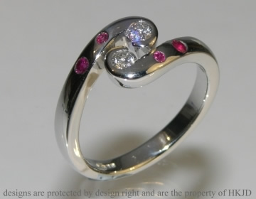 Bespoke platinum engagement ring with two brilliant cut diamonds and invisibly set rubies