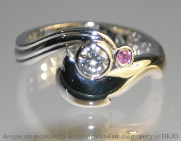 Bespoke 18ct white gold dolphin and wave inspired engagement ring with 0.25ct H SI brilliant cut diamond and 2mm brilliant cut pink sapphire.