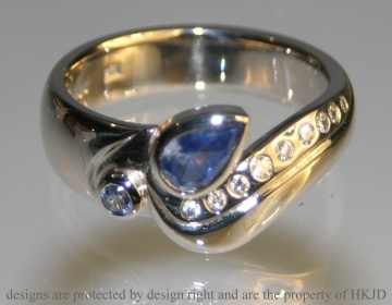 18ct white gold ring with pear shaped .44ct sapphire with 11 brilliant cut diamonds and a 2mm pale blue sapphire 