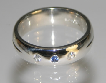 Bespoke platinum wedding ring with blue sapphire and diamonds