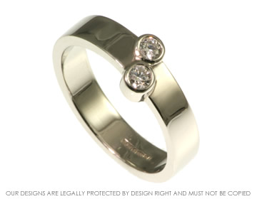 Platinum engagment ring with a pair of brilliant cut diamonds.  