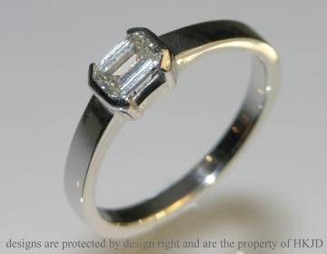 A platinum and 0.40ct emerald cut diamond engagement ring. 