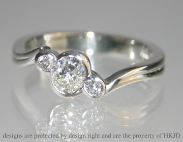 Platinum engagement ring with oval cut 0.42ct diamond and two 2mm diamonds 