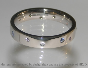 Bespoke 18ct white gold eternity ring with scattered diamonds and sapphires.