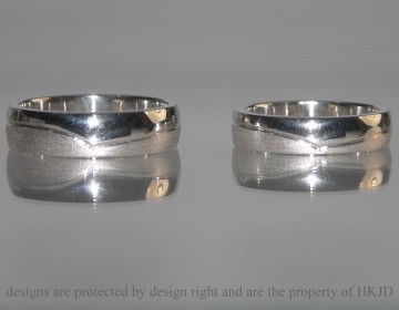 A pair white gold wedding rings with engraved waved line and contrasting finishes